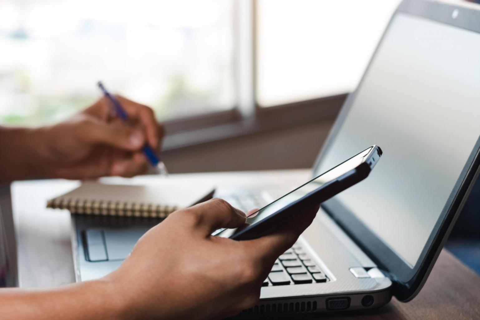 Mani che scrivono delicatamente su un diario, circondate da oggetti di memoria